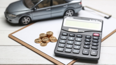 car model,calculator and coins on white table