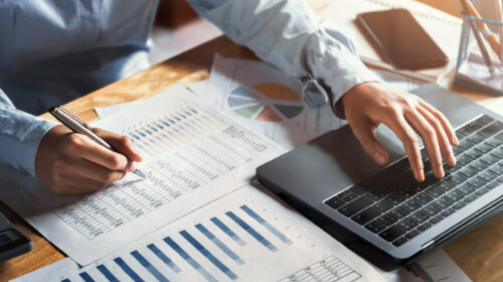 businesswoman working on desk using laptop for check data of finance in office